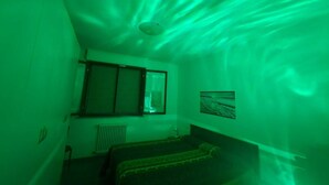 Una habitación con ventana, radiador y cama.