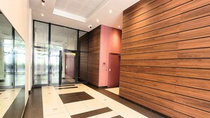 A modern interior with a patterned floor, glass doors, and wooden panel walls. - N&J - VAGUE AZUR - Central - Balcony (Niza)