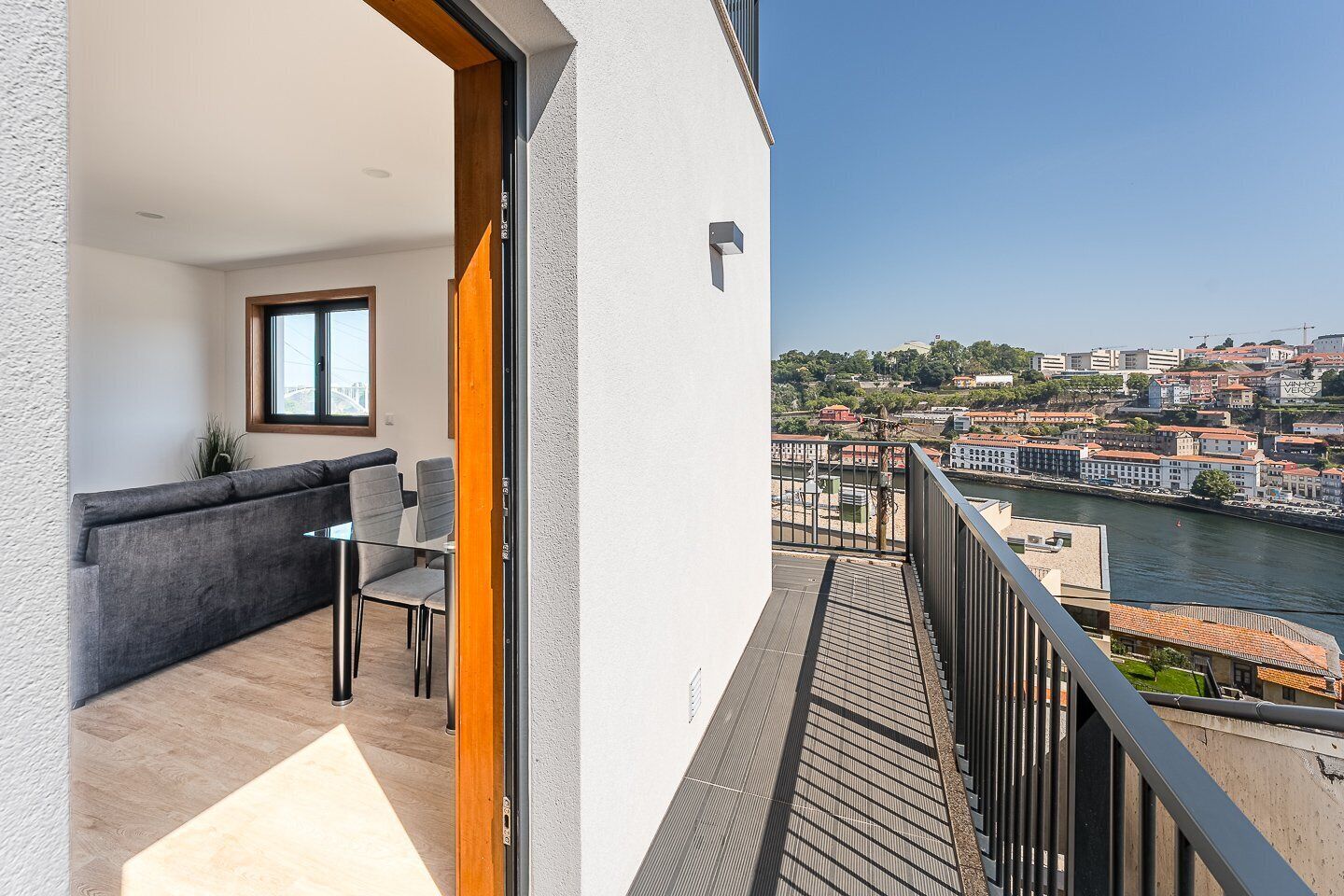 A balcony with a view of a river and cityscape.