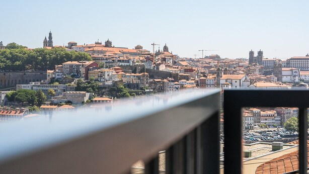 A panoramic view of a historic cityscape with a prominent church tower and dense urban buildings. - GuestReady - Stunning Douro River Vista (Vila Nova de Gaia)