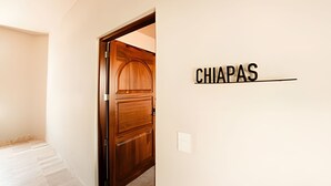 A hallway with a wooden door and a sign that reads "CHIAPAS". - Chiapas boutique apartment (Bucerías)
