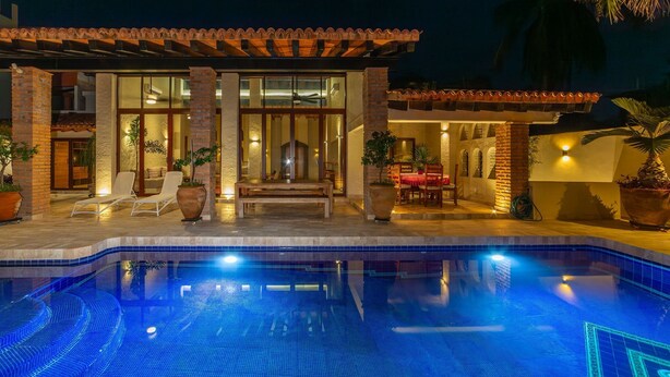 A poolside area with a pool, lounge chairs, and a covered patio. - Casa Riviera complex with 3 pools (Bucerías)