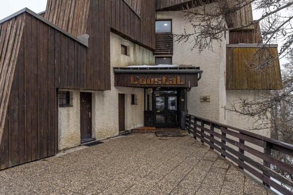 A rustic building with a wooden facade and a sign that reads "Lustal".