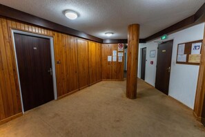 A hallway with wooden paneling, carpeted floors, and doors numbered 66 and 67. - 50m from ski slopes, 5th floor, view forest, balcony, tv, 28m², Les Orres (Les Orres)