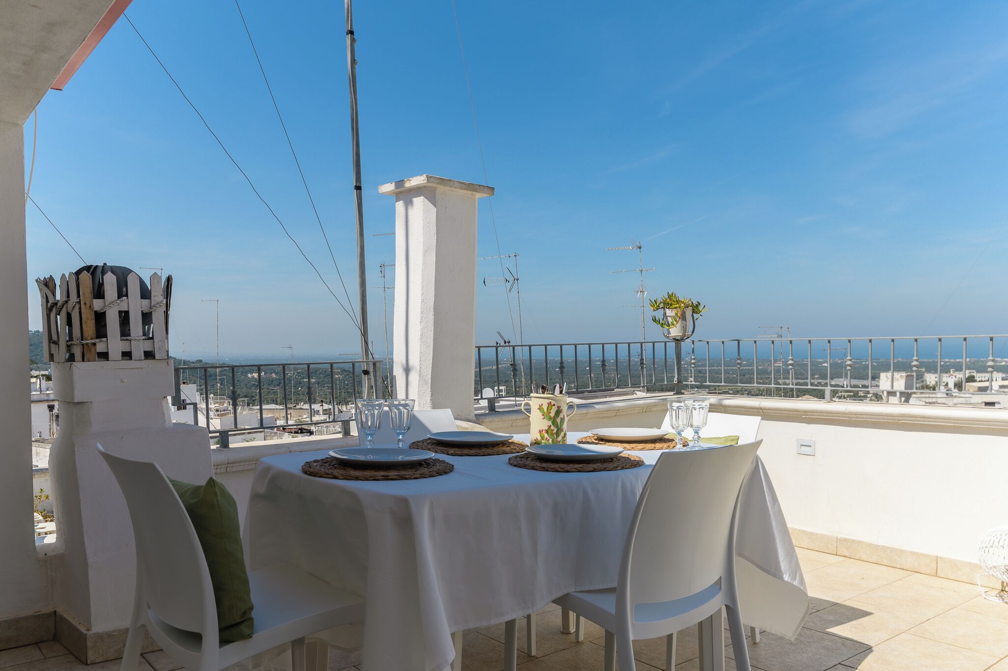 Ein Dachterrassen-Essbereich mit Tisch für vier Personen, mit Blick auf eine schöne Aussicht.