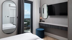 A modern hotel room with a bed, a large mirror, a TV, and a view of the outdoors. - Luxury Villa David 1 heated pool 38m2 bbq Seaview (Podstrana)