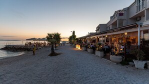 A beachside restaurant with outdoor seating, a pebble path, and a view of the sea. - Luxury Villa David's two heated pools 38m2 bbq Seaview (Podstrana)
