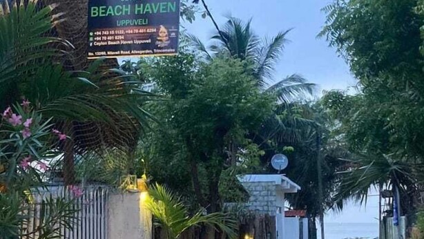 A dirt road leading to a gated area with a sign for 'Beach Haven Uppuveli'. - Ceylon Beach Haven Uppuveli (Trincomalee)