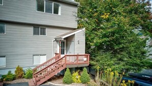 A two-story building with a wooden staircase leading to a small porch. - 4BR/4Bath Townhome w/AC, Walk to Ski, Golf, Tennis, Hiking and More! (Sugar Mountain)