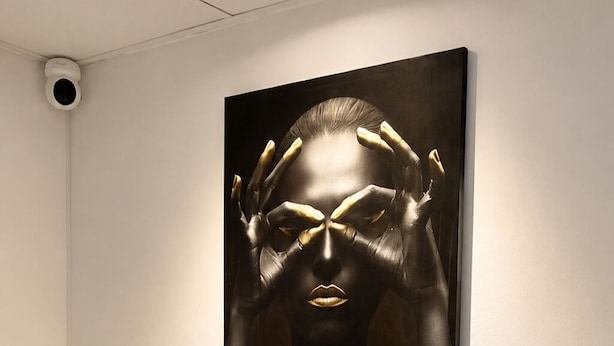 A room with a white desk, four white chairs, and a black and gold artwork on the wall. - WeStay Capsule Hostel (Dubai)