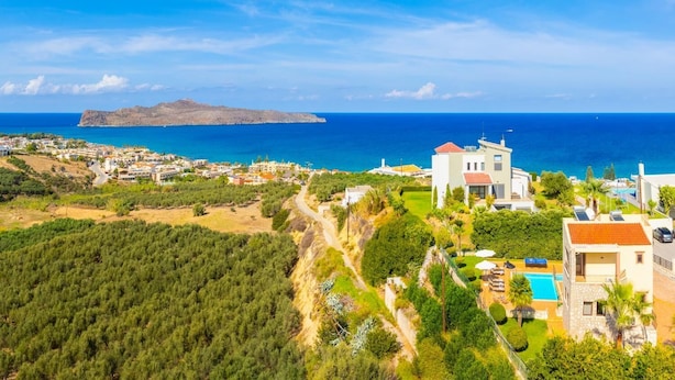 Um imóvel costeiro com uma casa grande, piscina e vista para o mar.
