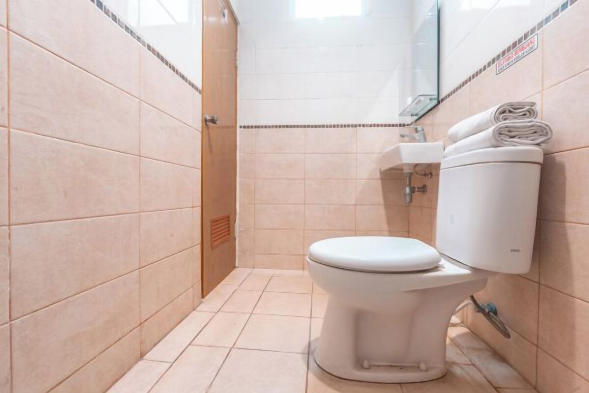 Une petite salle de bain moderne, équipée de toilettes, d’un lavabo et d’un miroir.