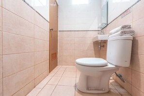 Une petite salle de bain moderne, équipée de toilettes, d’un lavabo et d’un miroir.