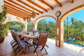 Enjoy meals under the open sky in a charming outdoor dining area with a long table and covered walkway.