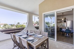 Enjoy a meal on the balcony with a view of the surrounding landscape, featuring a dining setup for two.