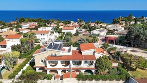 Zona residencial costera con casas de techos rojos y paredes blancas.