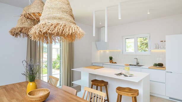 A modern kitchen with white cabinetry, a central island, bar stools, and hanging woven light fixtures. - Hedera Estate, Villa Hedera XVIII (Mlini)