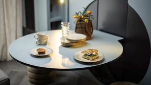 Une table ronde avec une assiette à dessert, une tasse, un verre et une plante.