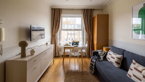 Ein modernes Wohnzimmer mit einer Couch, einem Esstisch und einem Fernseher.