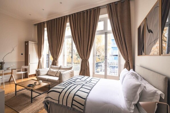 Una habitación de hotel con cama, sofá, mesa de centro y escritorio con silla.