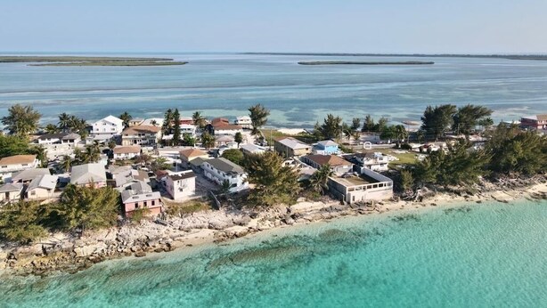 Vista aérea de una zona residencial costera con casas cerca de la playa y el océano.