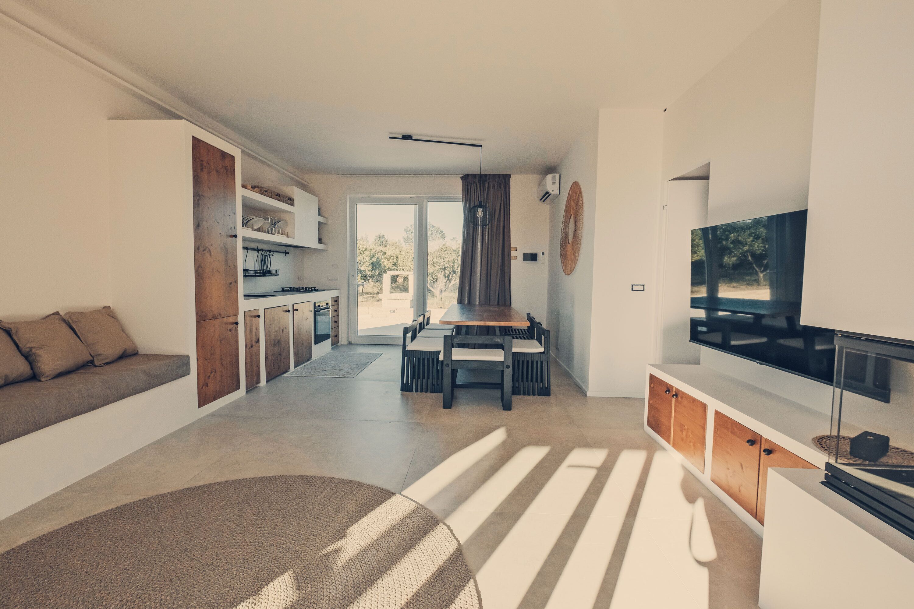 Una sala moderna con sofá, mesa de comedor y televisor.