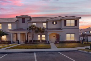 A multi-story residential building with a flat roof, multiple windows, and a well-maintained lawn. - Last Minute Disney Getaway! Private Pool & Themed Bedrooms. Book Now! #65583 (Orlando)