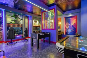 Una habitación con mesa de fútbol, carteles de Star Wars y techo con temática de Star Wars.