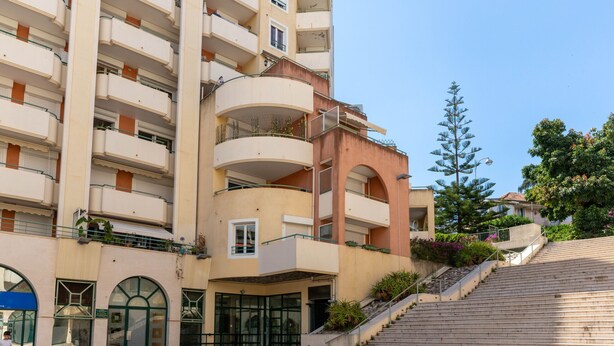 A multi-story hotel with balconies, a staircase, and a clear sky. - Happyfew Palais des arts (Nice)