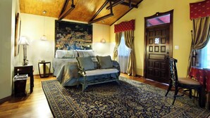 A bedroom with a bed, a chair, a rug, and a door.