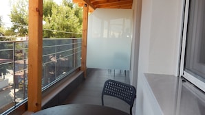 Un balcon doté d’un plafond en bois, d’une table ronde et d’une chaise.
