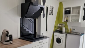 Eine moderne Küche mit Einbauofen, Waschmaschine und Kaffeemaschine.