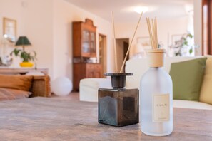 Une bouteille de Culti Aramara est posée sur une table en bois, et une autre bouteille, de forme carrée et de couleur noire, se trouve à côté.