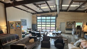 Una habitación amplia con un ventanal grande, un sofá, una mesa de comedor y una zona de cocina.