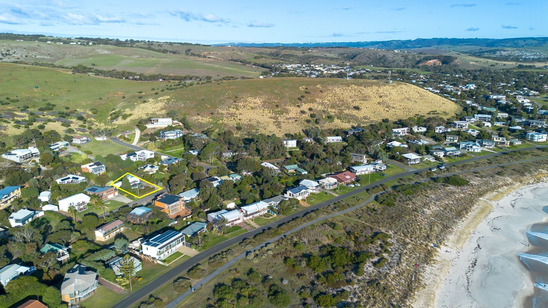 Vista aérea de una zona residencial con casas, carreteras y una playa.