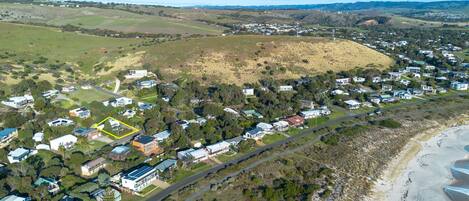 Vista aérea de una zona residencial con casas, carreteras y una playa.