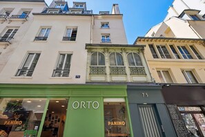 Un bâtiment dont la devanture est verte et sur laquelle on peut lire les mots « ORTO » et « PANINO » sur la vitrine.