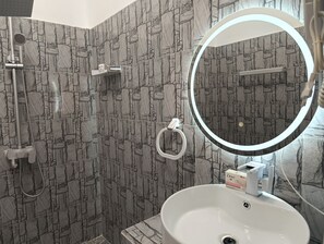Luxe tweepersoonskamer, uitzicht op het strand | Badkamer | Een douche, een haardroger, handdoeken, zeep