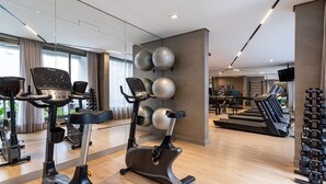 Ein modernes Fitnessstudio mit Ergometer, Crosstrainern und Laufbändern.