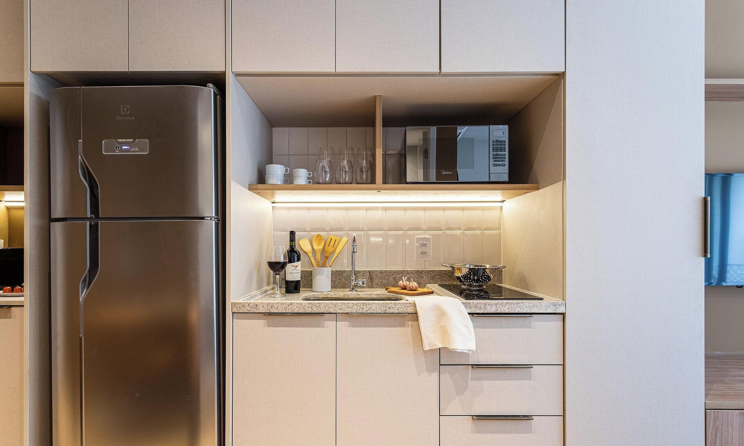 A modern kitchen with a stainless steel refrigerator, a microwave, and a built-in oven.