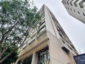 A high-rise building with a modern architectural design, featuring a prominent vertical line pattern and large windows. - For You Paraiso by Viva - Prédio com piscina e academia próximo ao metrô (São Paulo)