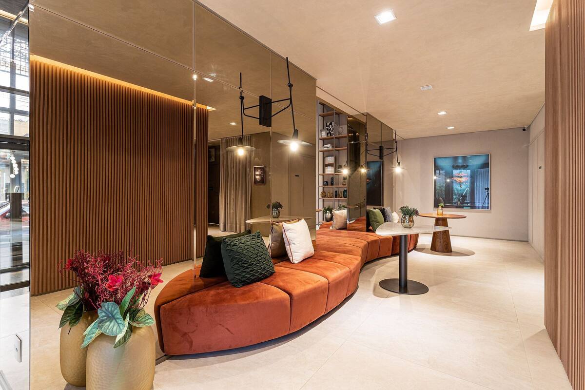 Un intérieur moderne avec un espace salon aux lignes courbes, une table à manger et des luminaires suspendus.