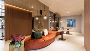 Ein modernes Interieur mit einer gebogenen Sitzecke, einem Esstisch und Pendelleuchten.