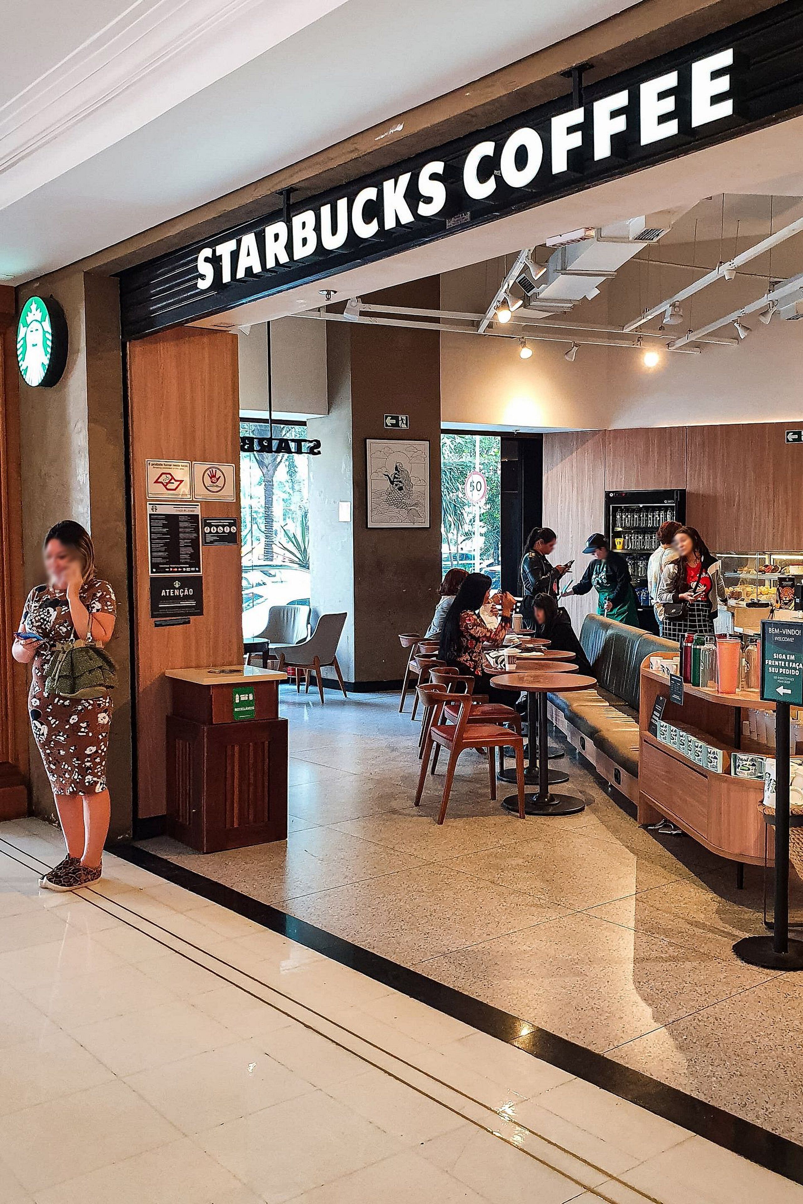 Un café Starbucks doté d’un espace salon, d’un comptoir et d’un panneau affichant le menu.