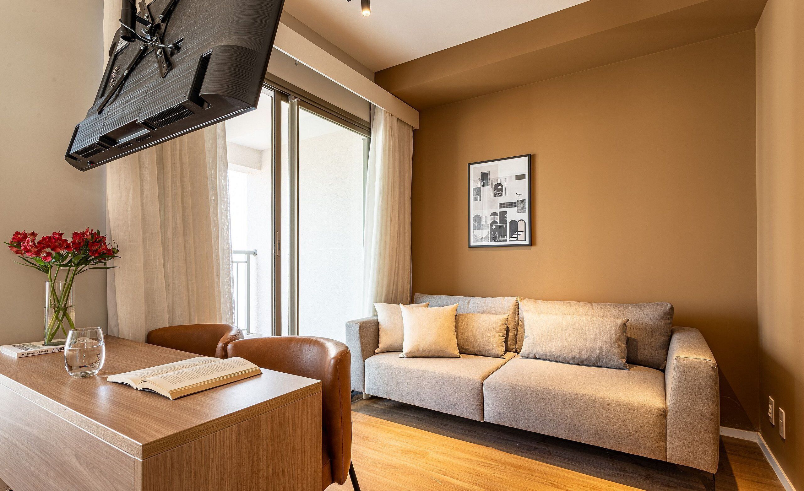 Ein modernes Wohnzimmer mit einer Couch, einem Esstisch mit Stühlen, einem Fernseher und einem Fenster mit Vorhängen.