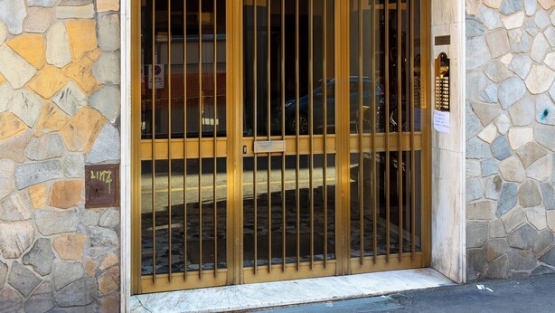 Ένα κτίριο από πέτρα με μεταλλική πύλη και κλειδαριά με αριθμητικό πληκτρολόγιο.