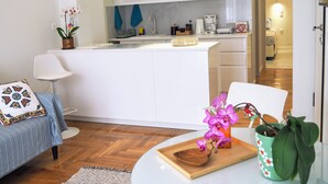 A modern kitchen with white cabinets, a central island, and a dining area with a table and chairs. - Athens White House 🏠  (Athina)