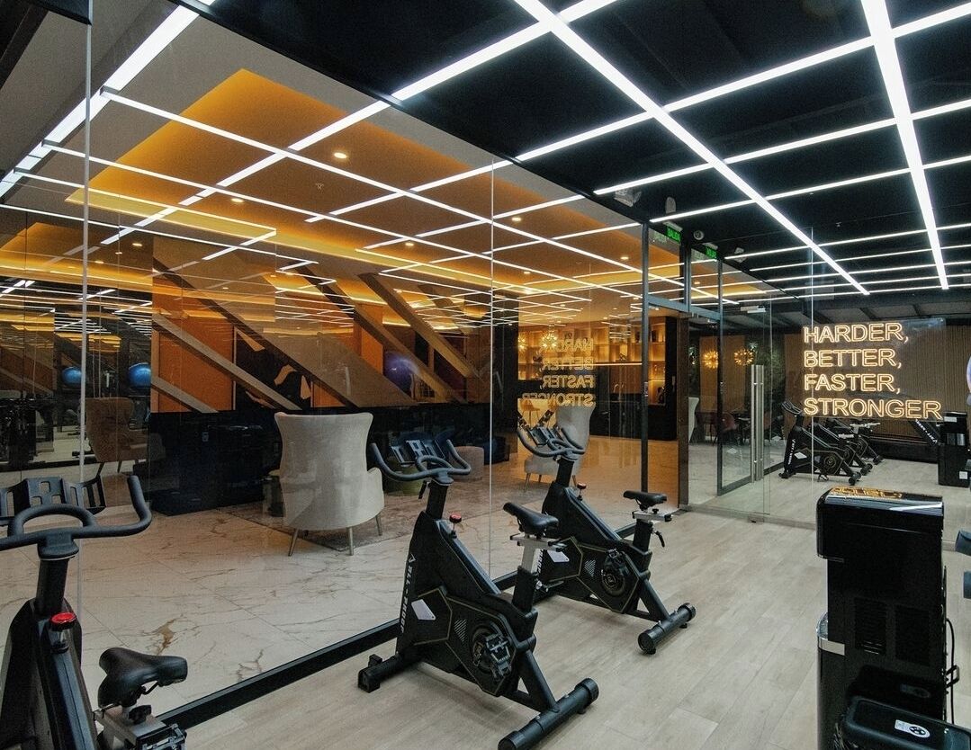 Ett gym med motionscyklar, en spegel och motiverande texter på väggen.