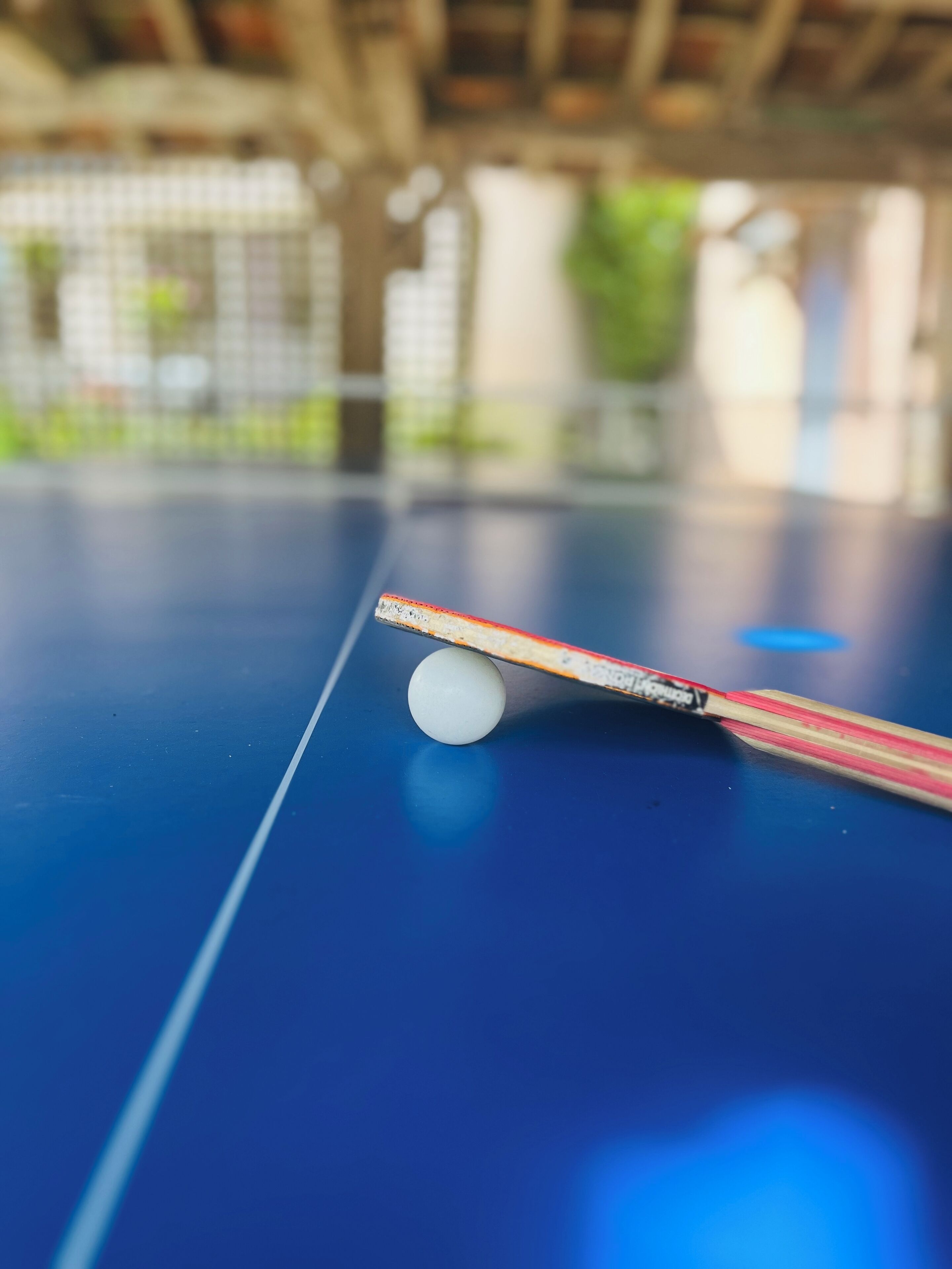 A close-up of a table tennis table with a paddle and ball.