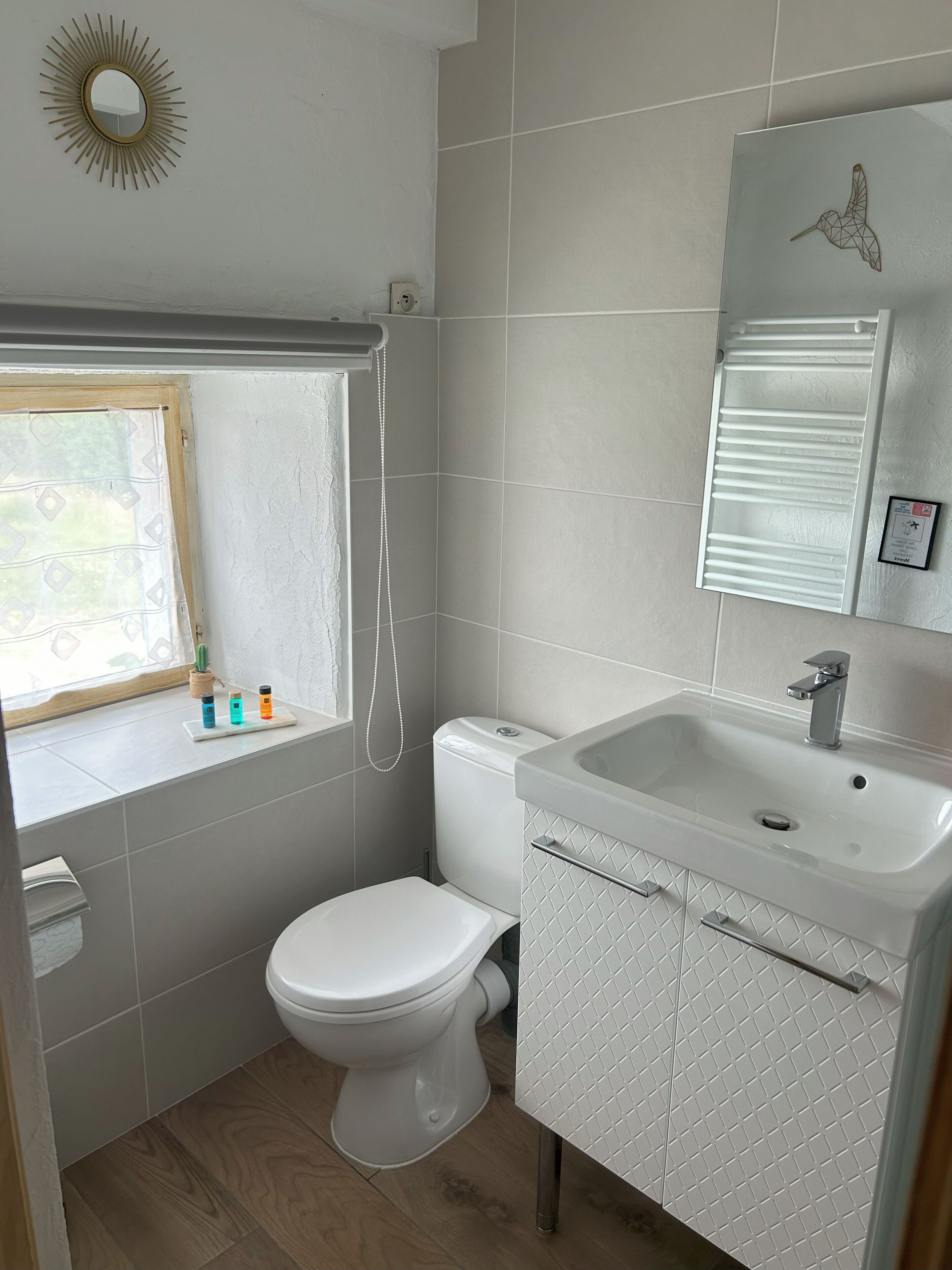 A compact bathroom with a toilet, sink, and window.